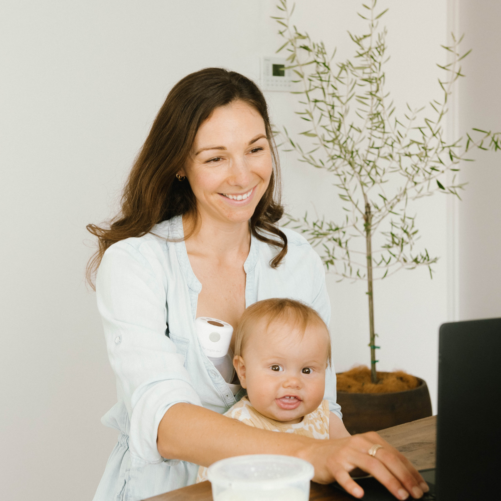 Working mother with baby and Night Owl portable breast pump for return to work breastfeeding routine