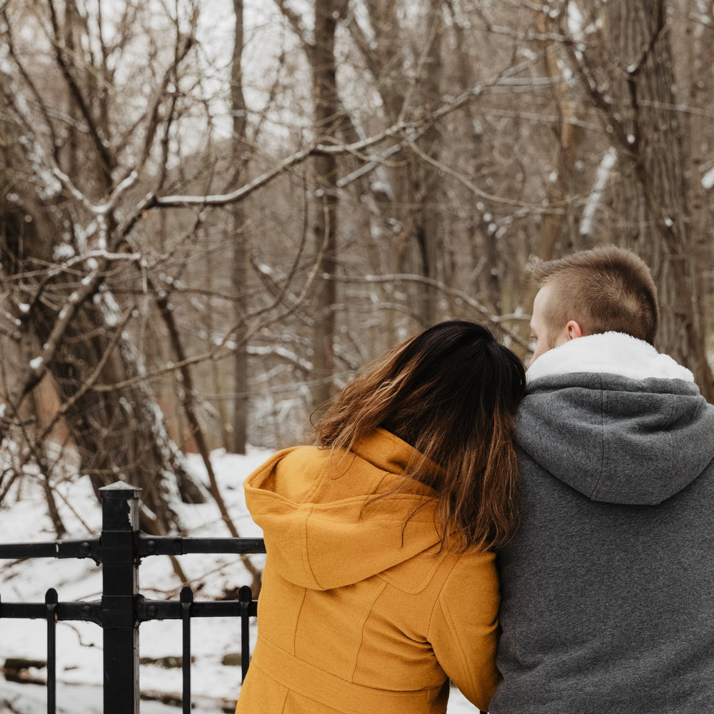 Loving couple embracing in winter snow representing relationship strength and support during parenthood journey