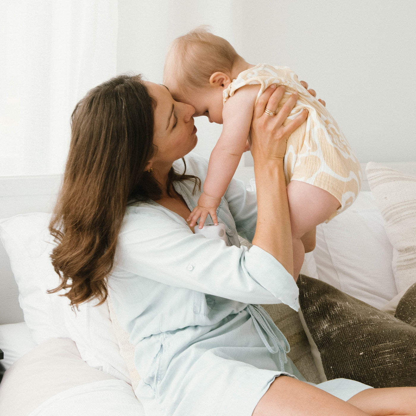 Parent holding baby on bed